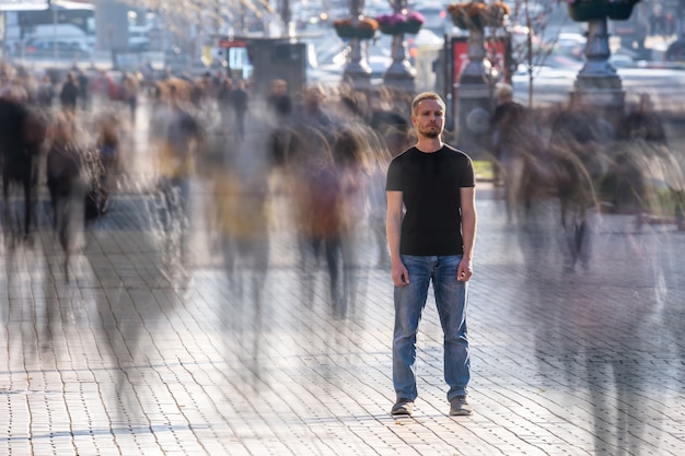 Foto el hombre está parado en la calle llena de gente