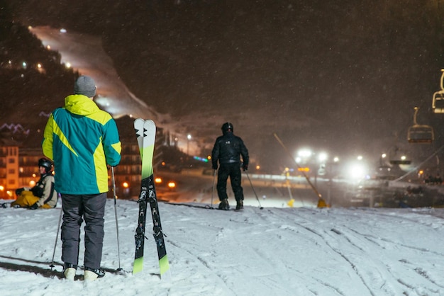 Hombre parado en la cima de una colina nevada listo para esquiar