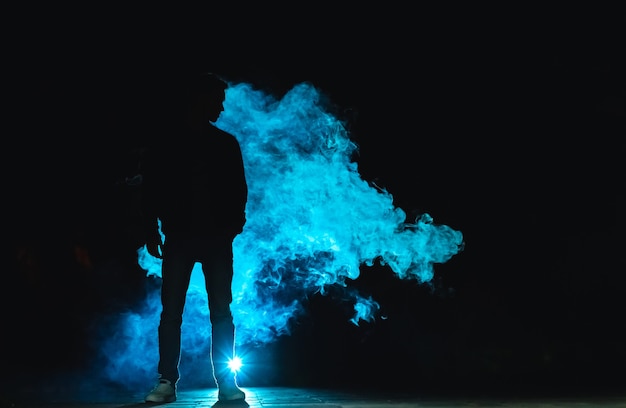 El hombre parado en el humo. tarde noche