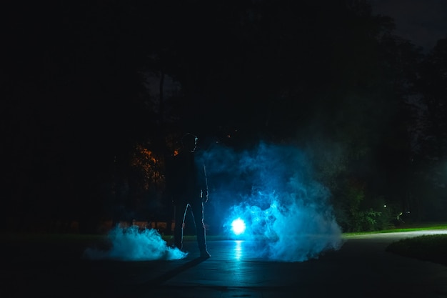 El hombre parado en el humo. tarde noche