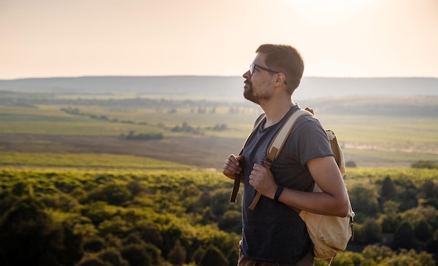 Un hombre parado en una montaña mientras se pone el sol.