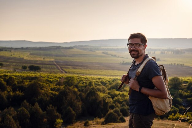 Foto un hombre parado en una montaña mientras se pone el sol.