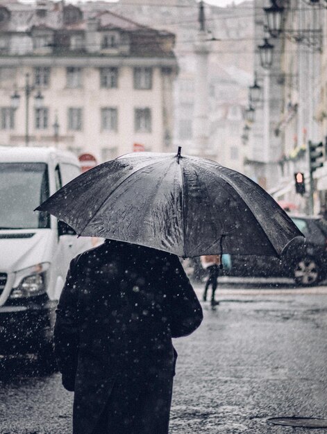 Hombre con paraguas en la calle durante la temporada de lluvias