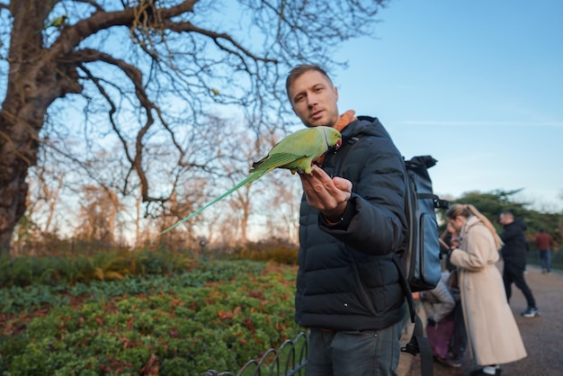 Hombre se pasea con un loro en un parque de Londres en medio de la temporada de Navidad