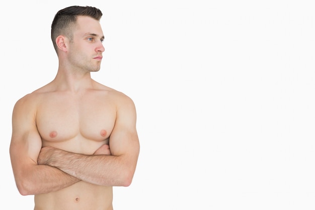 Foto hombre de pecho desnudo con los brazos cruzados mirando a su lado