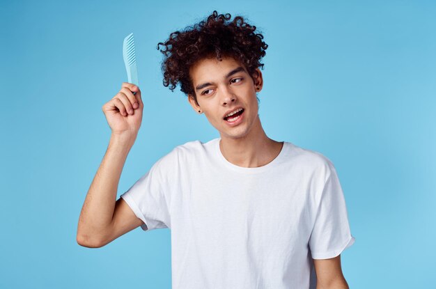 Foto hombre peinando el cabello rizado en su cabeza modelo de rizos enredados dolor