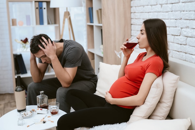 Un hombre pelea con una chica embarazada que bebe alcohol.