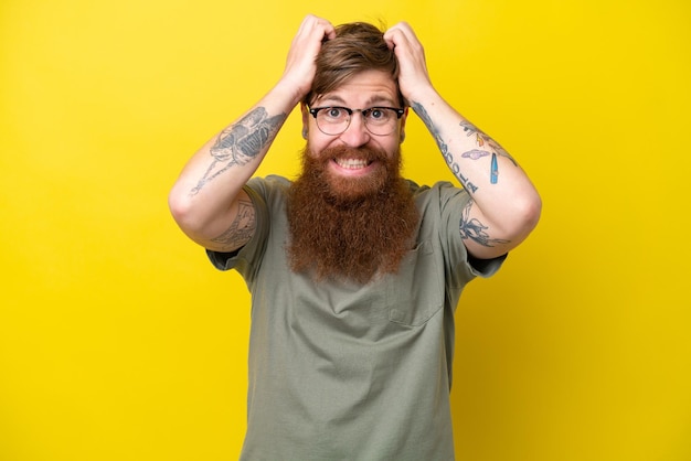 Hombre pelirrojo con barba aislado sobre fondo amarillo haciendo gesto nervioso