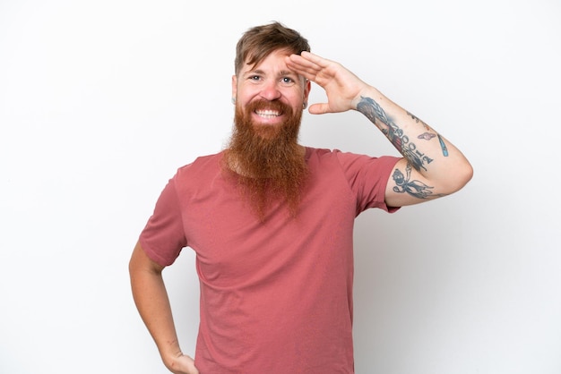 Foto hombre pelirrojo con barba larga aislado sobre fondo blanco saludando con la mano con expresión feliz