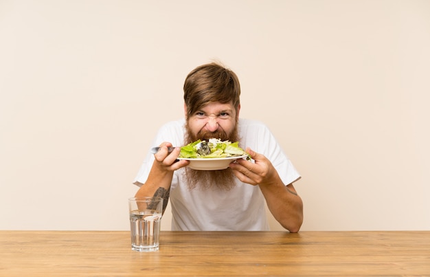 Hombre pelirrojo con barba larga y ensalada