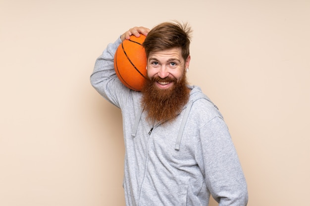 Hombre pelirrojo con barba larga con pelota de baloncesto