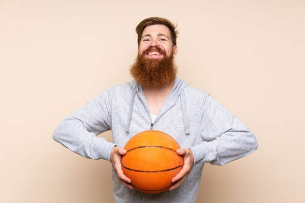 Hombre pelirrojo con barba larga con pelota de baloncesto