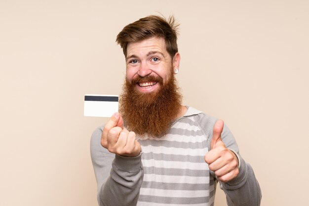 Hombre pelirrojo con barba larga con una tarjeta de crédito