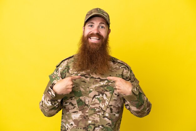 Hombre pelirrojo militar sobre aislado sobre fondo amarillo con expresión facial sorpresa