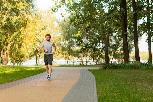 Hombre pelirrojo y pecoso corriendo en el parque