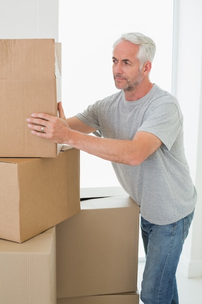 Hombre pensativo mirando cajas de cartón en movimiento