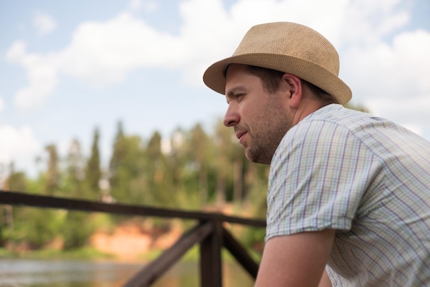 Hombre pensativo pensando descansando al aire libre cerca del lago