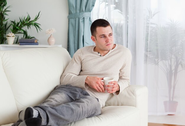 Hombre pensativo sosteniendo una taza de café