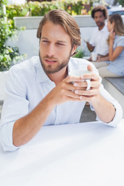 Hombre pensativo tomando un café