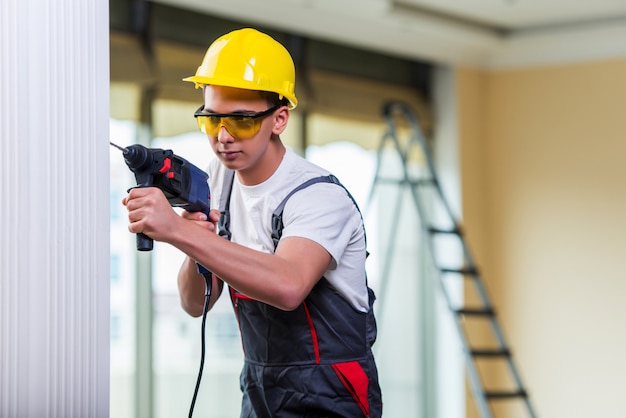 Hombre perforando la pared con taladro perforador