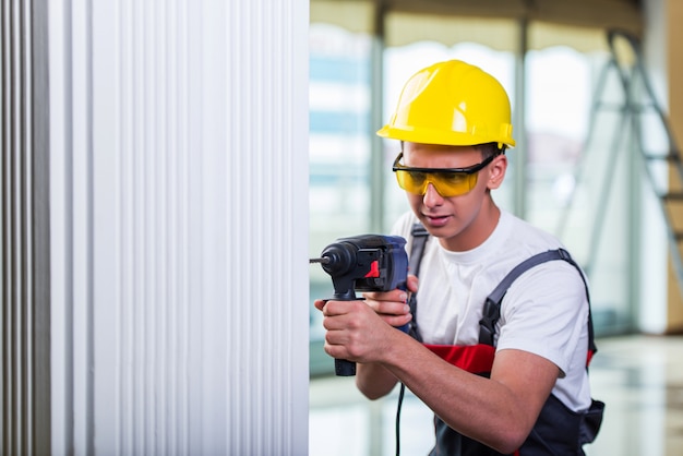 Hombre perforando la pared con taladro perforador