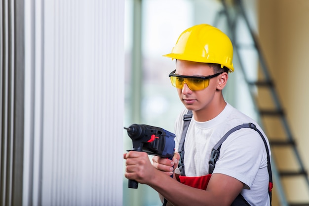 Hombre perforando la pared con taladro perforador