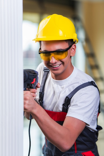 Hombre perforando la pared con taladro perforador