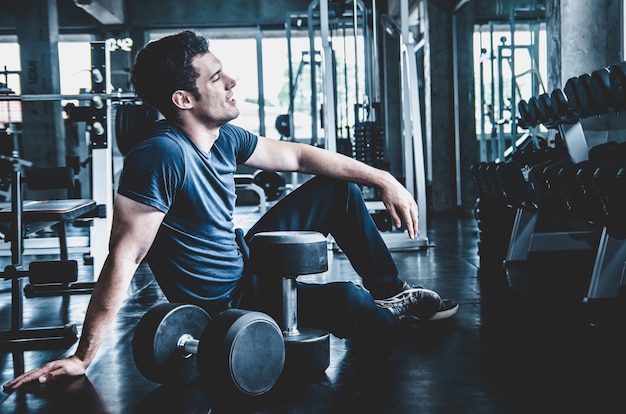 Hombre pickup dumbell en gimnasio