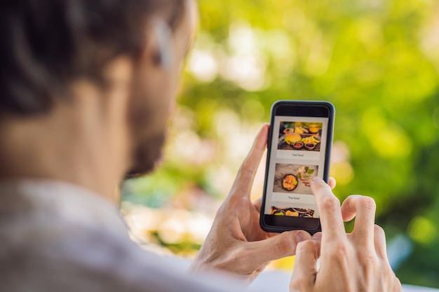 Hombre pide comida para el almuerzo en línea usando su teléfono inteligente