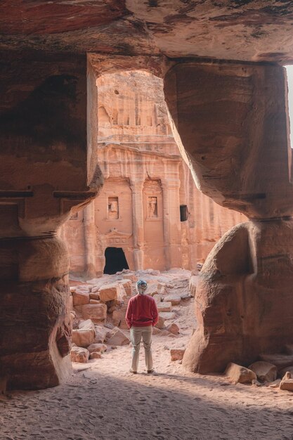 Foto hombre de pie en una abertura rocosa en petra