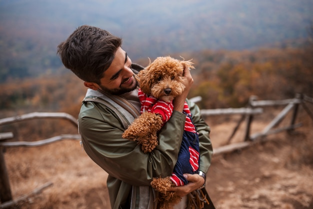 Hombre de pie al aire libre y con perro