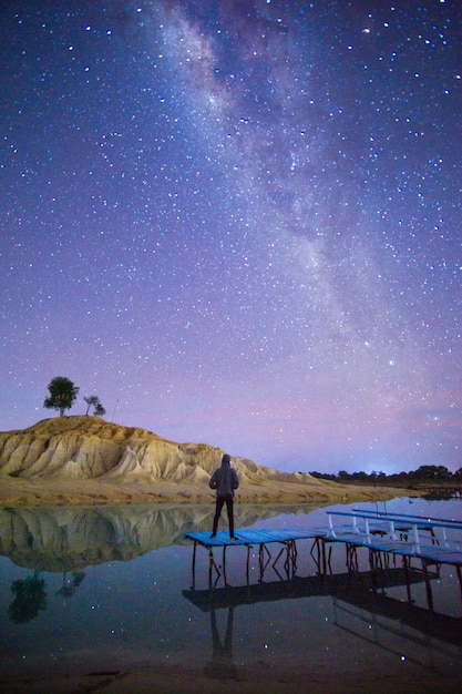 Foto hombre de pie en el campo contra el cielo por la noche