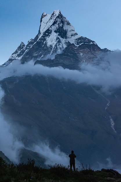 Foto hombre de pie contra las montañas cubiertas de nieve