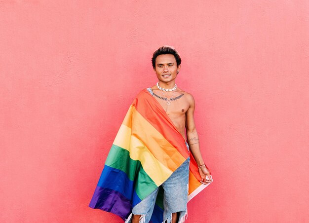 Foto hombre de pie contra la pared rosa