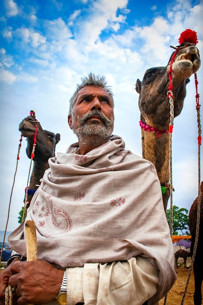 Un hombre de pie entre dos camellos