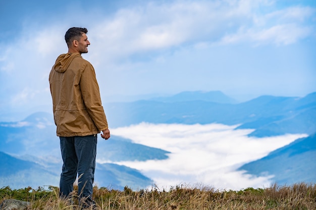 El hombre de pie en el fondo del paisaje de montaña