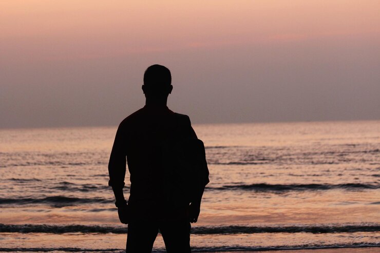 Un hombre de pie frente al amanecer en el Mar Báltico