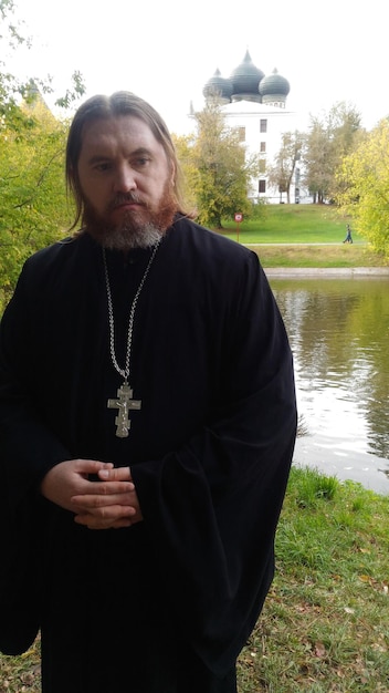 Hombre de pie junto al lago contra la iglesia