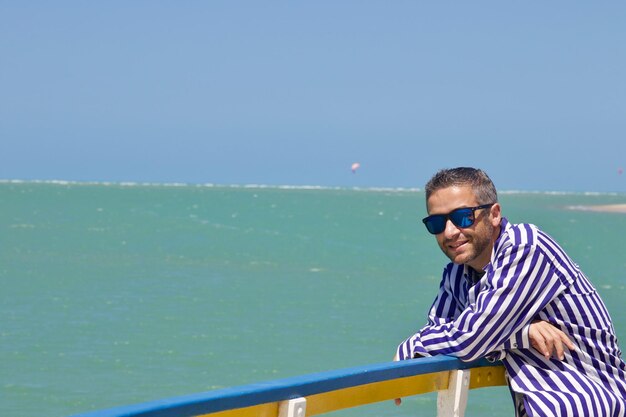 Foto hombre de pie junto al mar