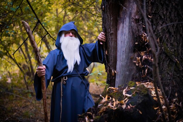 Hombre de pie junto al tronco de un árbol en el bosque