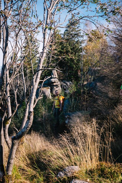 Hombre de pie junto a las plantas en el bosque