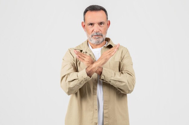 Foto hombre de pie con las manos cruzadas delante del pecho