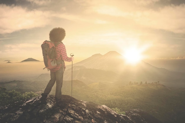 Hombre de pie en la montaña contra el cielo durante la puesta de sol