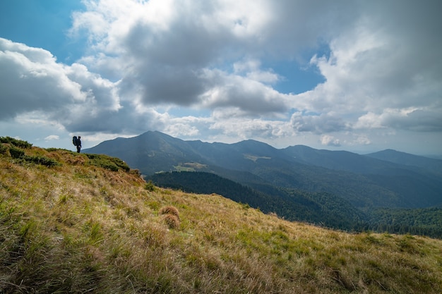 El hombre de pie en la montaña en el fondo de la nube