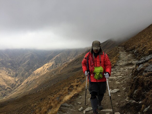 Foto hombre de pie en la montaña durante el invierno