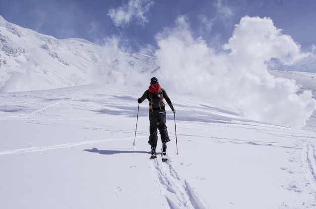 Hombre de pie en un paisaje cubierto de nieve contra el cielo