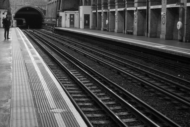 Hombre de pie en la plataforma de la estación de tren