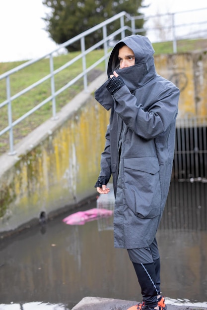 Hombre de pie en el puente peatonal en la lluvia durante la temporada de lluvias