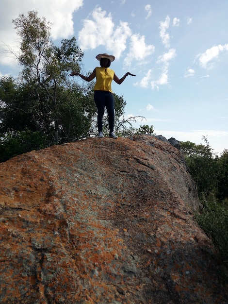 Hombre de pie en la roca contra el cielo