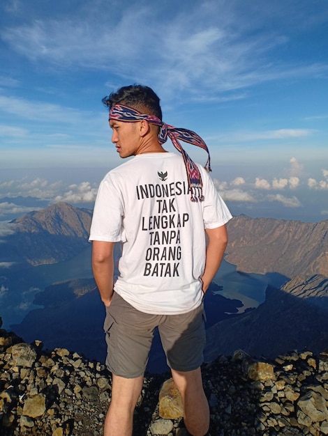 Hombre de pie en la roca contra las montañas